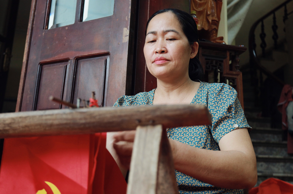 Chị Vương Thị Nhung (50 tuổi) - người đã gắn bó hơn ba thập kỷ với nghề thêu cờ Tổ quốc, một công việc tưởng chừng đơn giản, nhưng lại đòi hỏi sự chính xác và tinh thần trách nhiệm cao độ. anh-chup-man-hinh-2025-04-28-luc-134408.png