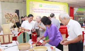 Phó Chánh Văn phòng Thường trực Văn phòng Điều phối Chương trình Xây dựng NTM Hà Nội Nguyễn Văn Chí thăm gian hàng trưng bày các sản phẩm làng nghề đặc sắc của Hà Nội 