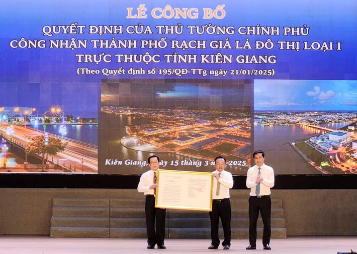 Lãnh đạo Bộ Xây dựng thừa ủy quyền trao quyết định của Thủ tướng Chính phủ về việc công nhận TP. Rạch Giá là đô thị loại I cho lãnh đạo thành phố (Ảnh: Phương Vũ). don-nhan-bang-1.jpg