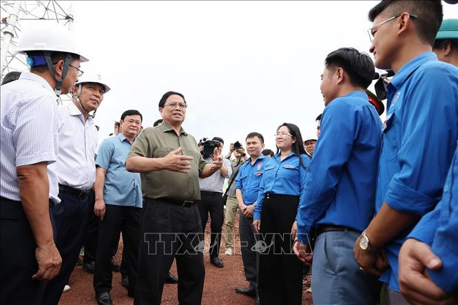 Thủ tướng Phạm Minh Chính động viên thanh niên trên công trường dự án Đường dây tải điện 500kV mạch 3 Quảng Trạch - Phố Nối đoạn qua tỉnh Nghệ An. Ảnh: Dương Giang/TTXVN Chú thích ảnh