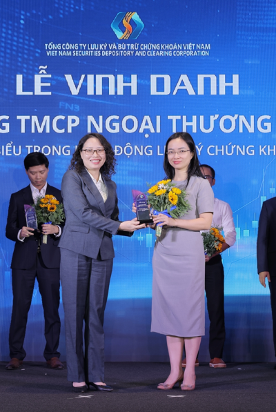 Tổng Giám đốc VSDC Tạ Thanh Bình (bên trái) trao tặng hoa và kỷ niệm chương cho đại diện Vietcombank - ngân hàng tiêu biểu trong hoạt động lưu ký chứng khoán năm 2024. Ảnh: VCB 20241121-vcb-la-thanh-vien-tieu-bieu-trong-hoi-dong-luu-ky-ck-2024-anh-2jpg.png