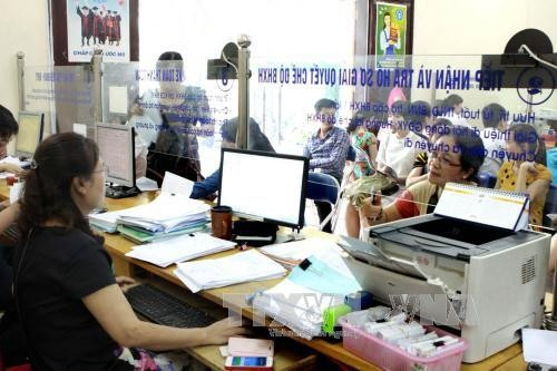 Giải quyết thủ tục về BHXH, BHYT tại Bảo hiểm xã hội quận Cầu Giấy. Ảnh tư liệu (minh họa): TTXVN Giải quyết thủ tục về BHXH, BHYT tại Bảo hiểm xã hội quận Cầu Giấy. Ảnh tư liệu (minh họa): TTXVN