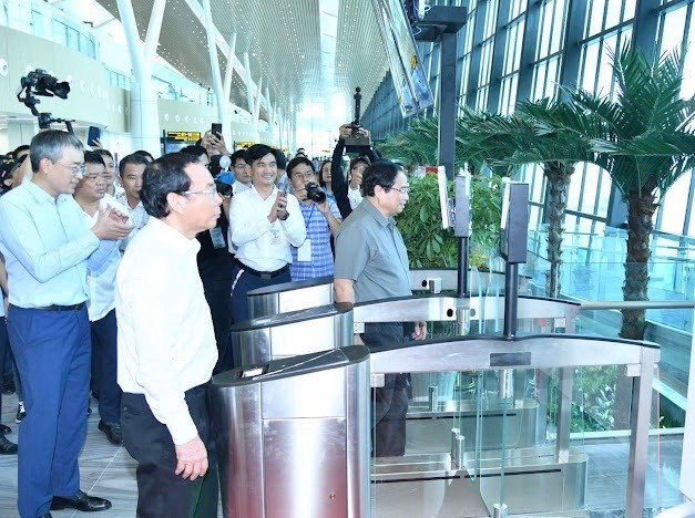 Thủ tướng Chính phủ Phạm Minh Chính cùng lãnh đạo các bộ, ban, ngành đã đến cửa ra máy bay số 12 của chuyến bay VN244 để trực tiếp kiểm tra quy trình làm thủ tục lên máy bay bằng công nghệ sinh trắc học tích hợp trong ứng dụng VNeID. Ảnh: VNA 86af382c625e6bfa737626bec3d9e87e.jpg