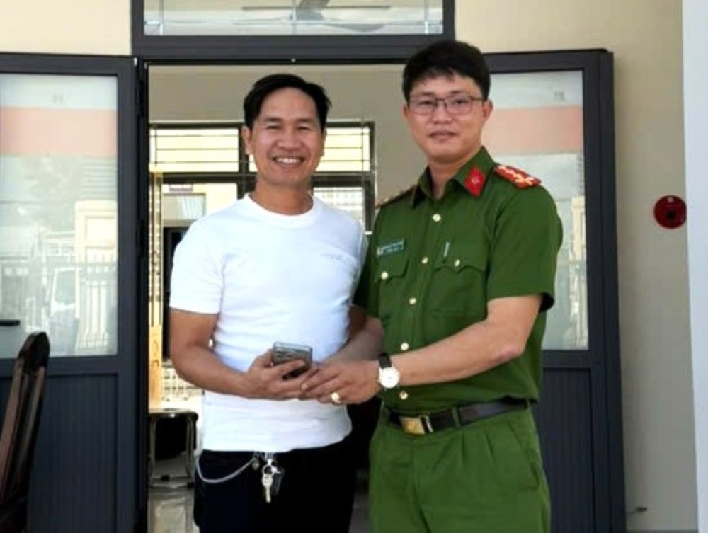 Đại úy Phạm Viết Minh Thạch trả lại chiếc điện thoại cho anh Trương Quốc Vĩnh tra-tai-san.jpg
