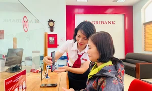 Cán bộ Agribank hướng dẫn khách hàng cài đặt sinh trắc học