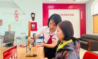 Cán bộ Agribank hướng dẫn khách hàng cài đặt sinh trắc học