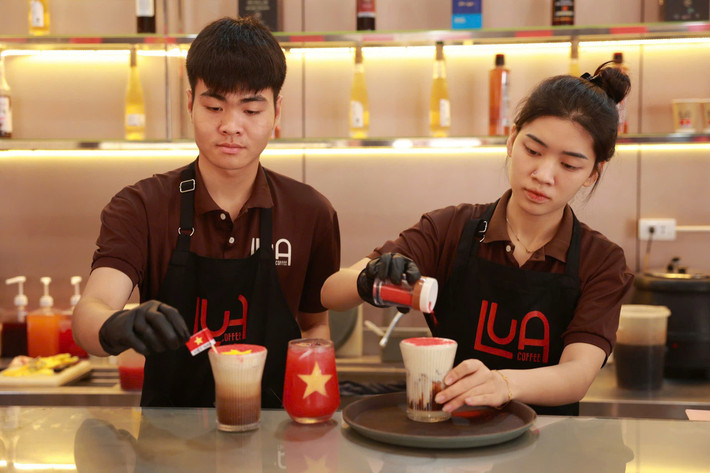 Hai bạn trẻ Nguyễn Đắc Công và Ngô Bích Ngọc trực tiếp tham gia pha chế, tạo hình lá cờ Tổ quốc lu-a-cafe-3.jpg