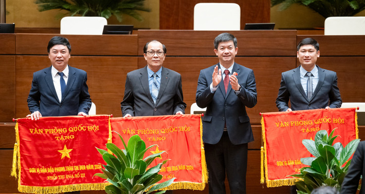 Tổng Thư ký Quốc hội, Bí thư Đảng ủy, Chủ nhiệm Văn phòng Quốc hội Lê Quang Tùng trao Cờ thi đua cho 3 tập thể dẫn đầu trong phong trào thi đua của Văn phòng Quốc hội. Ảnh: Hồ Long