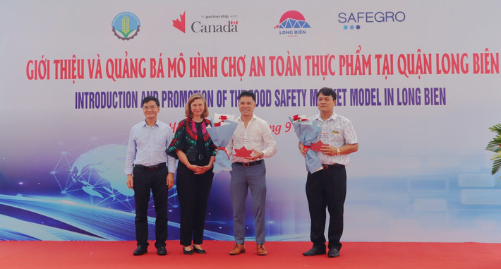 Đại diện Đại sứ quán Canada và Dự án SAFEGRO trao kỷ niệm chương ghi nhận đóng góp của BQL các chợ Thượng Thanh và Kim Quan. Ảnh: Đào Cảnh n2.jpg