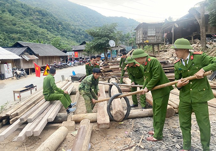 Lực lượng công an hỗ trợ người dân bản Văng Phao, xã Mường Típ, huyện Kỳ Sơn, tỉnh Nghệ An di dời tài sản, nhà cửa đến nơi tái định cư an toàn. Ảnh: cand.com.vn 13.jpg