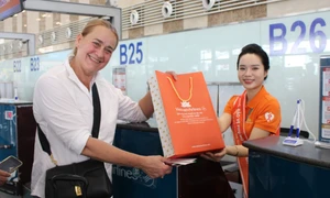 Khách nước ngoài hào hứng check-in với món quà của sự kiện. Ảnh: VNA