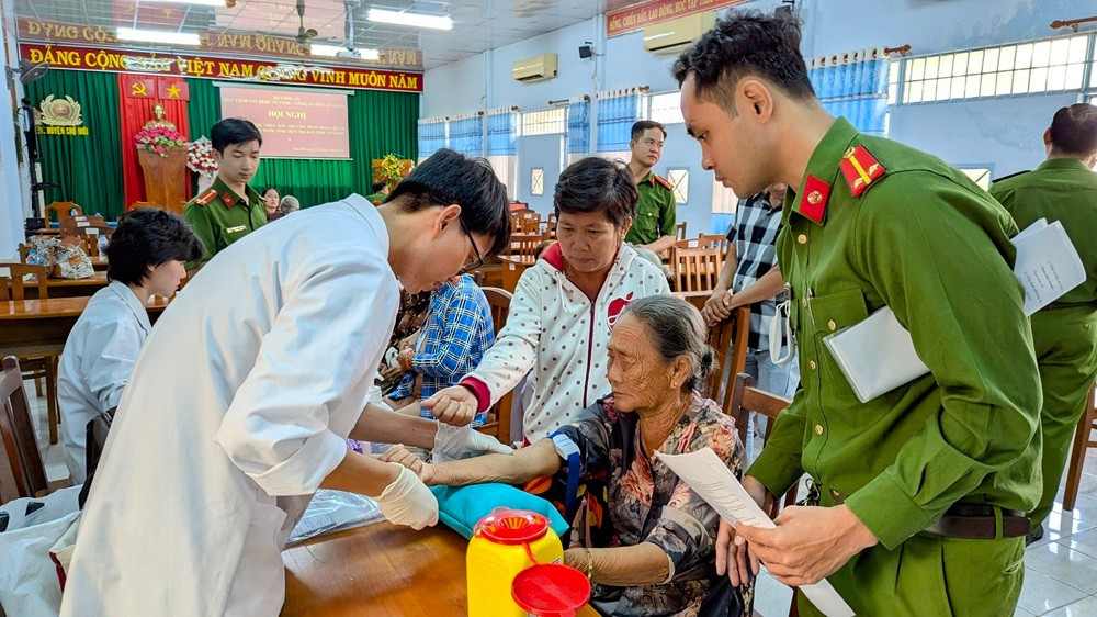 Cán bộ Công an An Giang cập nhật thông tin và thu nhận mẫu ADN thân nhân liệt sĩ chưa xác định được danh tính (Ảnh: Nghiêm Túc) thu-nhan-2.jpg