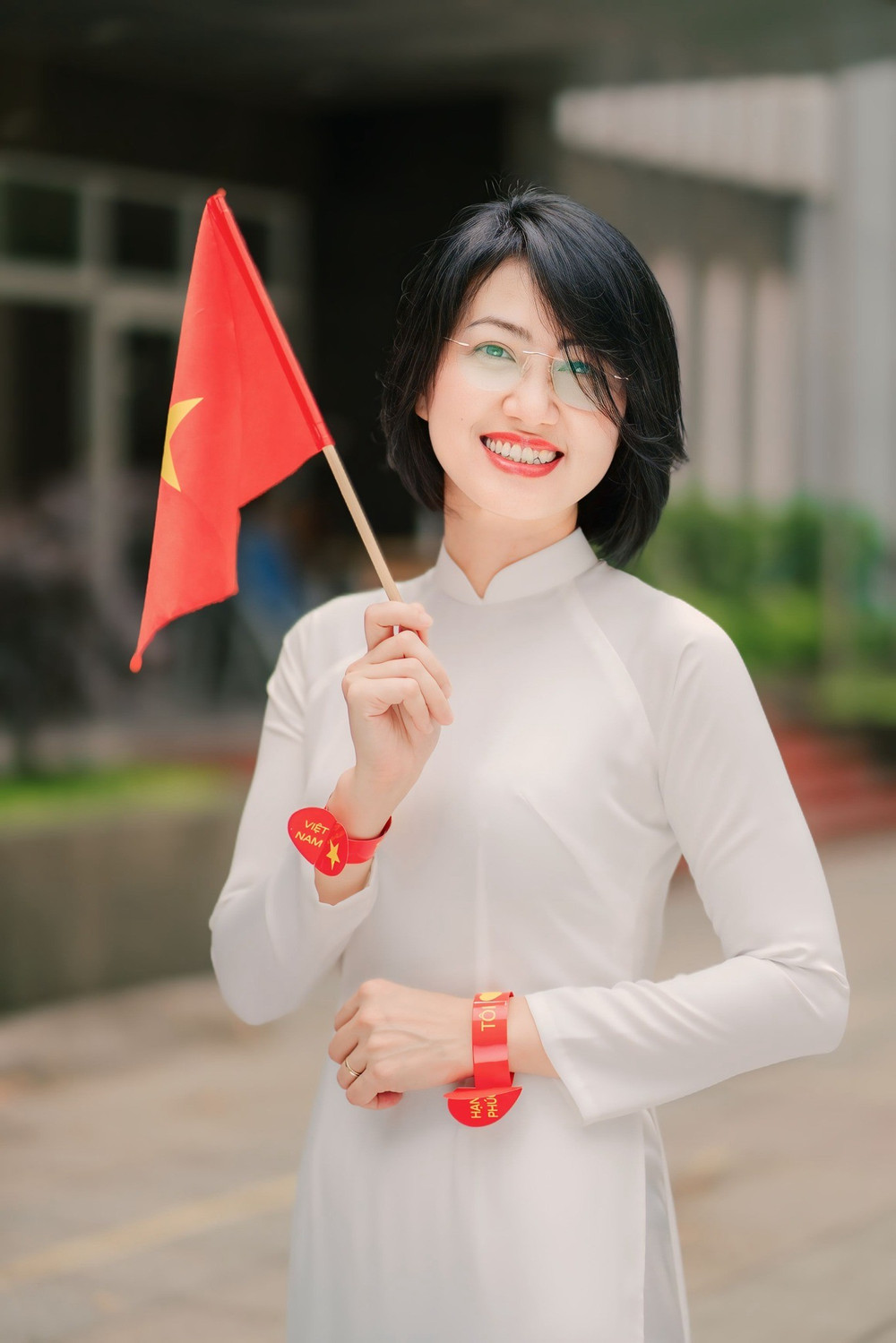 Giảng viên nữ Học viện Ngân hàng trong tà áo dài trắng bên lá cờ đỏ sao vàng. Ảnh: BAV 493761985-1090937576402865-9030744136813993129-n.jpg