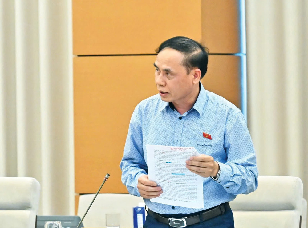 Phó Chủ nhiệm Ủy ban Pháp luật và Tư pháp Hoàng Văn Liên trình bày Báo cáo thẩm tra dự thảo Nghị quyết. Ảnh: Quang Khánh thay-1.jpg