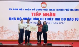 Đại diện lãnh đạo BHXH TP. Hà Nội trao tiền ủng hộ đồng bào vùng bão lũ.( Ảnh: BHXH T.P Hà Nội)