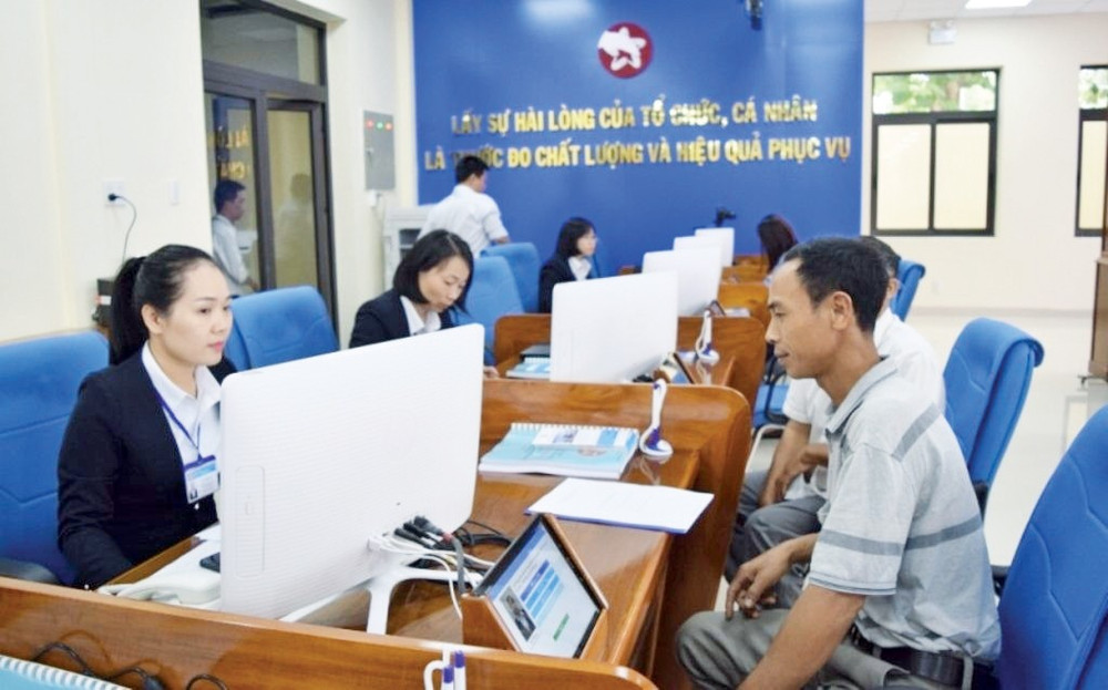 Người dân sử dụng máy tính bảng hoặc thiết bị điện tử để đánh giá chất lượng phục vụ của cán bộ tại quầy giao dịch. Nguồn: Baochinhphu.vn 13.jpg