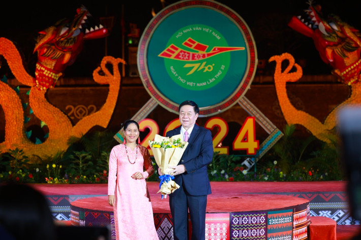 Nhà thơ Kiều Maily, dân tộc Chăm, thay mặt các nhà thơ người dân tộc tặng hoa Trưởng Ban Tuyên giáo Trung ương Nguyễn Trọng Nghĩa. Ảnh: Vũ Toàn Ngày thơ Việt Nam lần thứ 22 - Bản hòa âm đất nước: Tôn vinh vẻ đẹp của thi ca -0