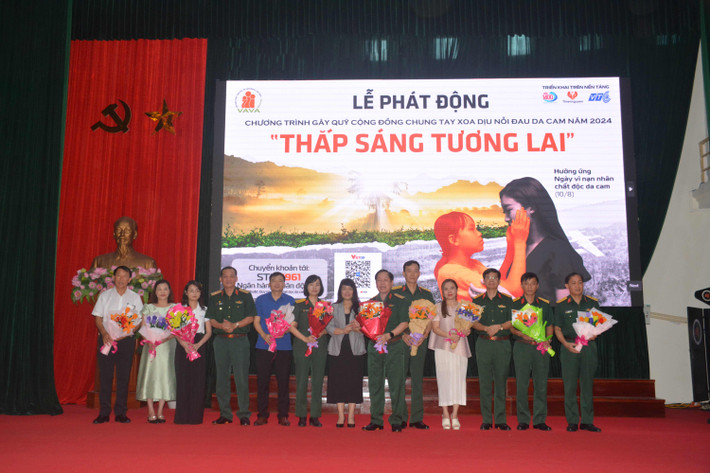 Trung tướng Nguyễn Hữu Chính, Chủ tịch Hội Nạn nhân chất độc da cam /dioxin Việt Nam tặng hoa tri ân những nhà hảo tâm. Ảnh: Trần Minh Quét mã QR ủng hộ nạn nhân chất độc màu da cam -0