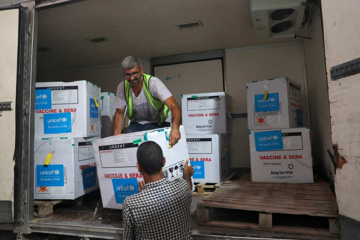 Nhân viên đang dỡ lô vaccine bại liệt được Unicef hỗ trợ tại một kho hàng thuộc Bộ Y tế Gaza. Ảnh: AFP Israel và Hamas sẽ tạm ngừng bắn để tiêm phòng cho trẻ em -0
