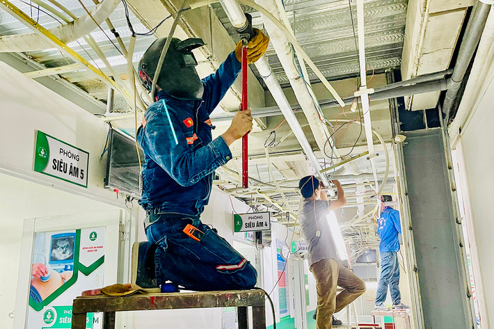 Khu vực trần nhà có nhiều công nhân đang hàn xì Bệnh viện đa khoa Medic - Bình Dương vừa khám chữa bệnh vừa thi công xây dựng hệ thống PCCC