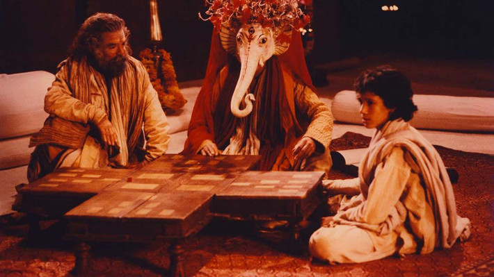 Cảnh trong phim của Peter Brook: hiền triết Vyasa kể sử thi cho Ganesha chép. Sử thi sẽ được trao lại cho chú bé thế hệ sau Cảnh trong phim của Peter Brook: hiền triết Vyasa kể sử thi cho Ganesha chép. Sử thi sẽ được trao lại cho chú bé thế hệ sau