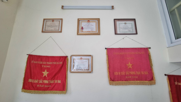 Một góc tường trong căn phòng làm việc của ông Lý treo đầy cờ và bằng khen. Chuyện về người cộng tác viên báo chí đặc biệt -0