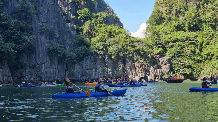 Du khách chèo kayak tại khu vực hang Luồn trên vịnh Hạ Long. Ảnh: Phan Hằng Bảo vệ môi trường Vịnh Hạ Long - phát triển du lịch bền vững -0
