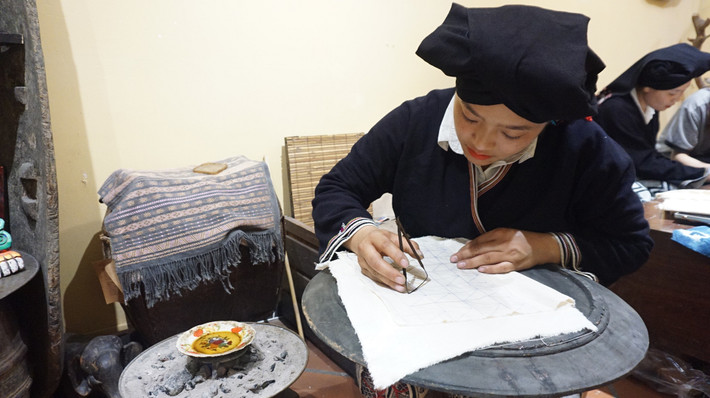 Phụ nữ Dao Tiền vẽ sáp ong lên vải Phụ nữ Dao Tiền vẽ sáp ong lên vải - Ảnh: Thái Minh