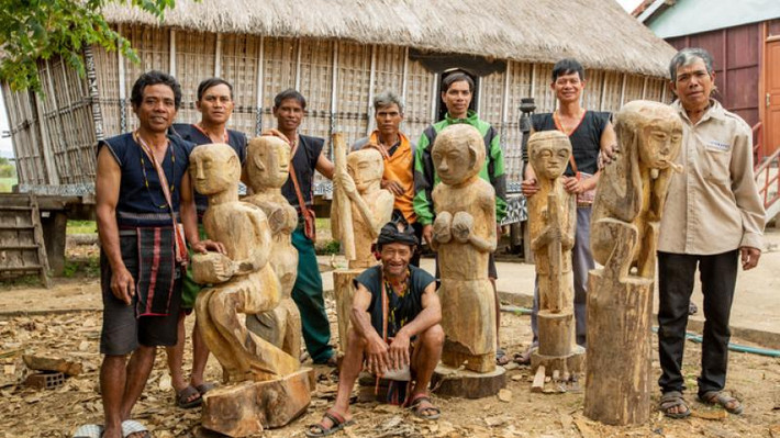 Dân làng Mơ H’ra, Gia Lai bên cạnh những bức tượng truyền thống. Ảnh: Hội đồng Anh Dân làng Mơ H’ra, Gia Lai bên cạnh những bức tượng truyền thống. Ảnh: Hội đồng Anh