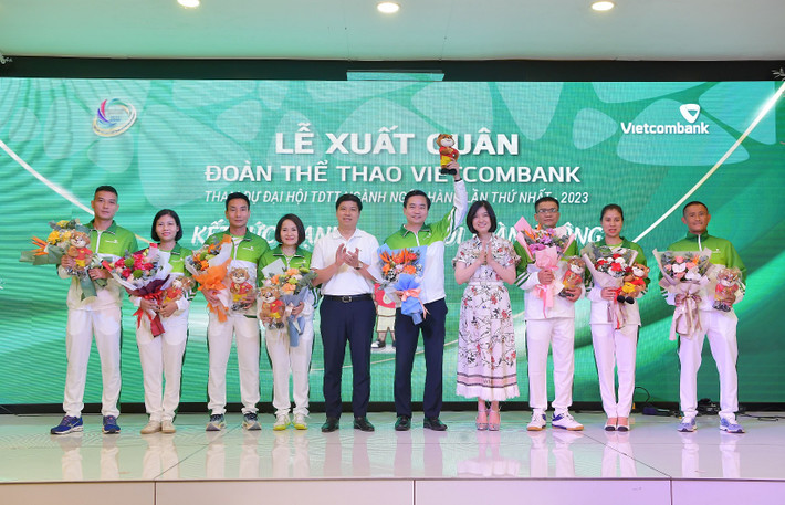 Ông Hồng Quang - Thành viên HĐQT, Giám đốc Khối Nhân sự, Chủ tịch Công đoàn Vietcombank (thứ 5 từ trái sang) cùng bà Phùng Nguyễn Hải Yến - Phó Tổng giám đốc (thứ 4 từ phải sang) trao linh vật đại hội và tặng hoa khích lệ tinh thần Đoàn thể thao Vietcombank. Nguồn: Vietcombank Lễ xuất quân đoàn thể thao Vietcombank tham gia Đại hội thể dục thể thao ngành Ngân hàng lần thứ nhất -0