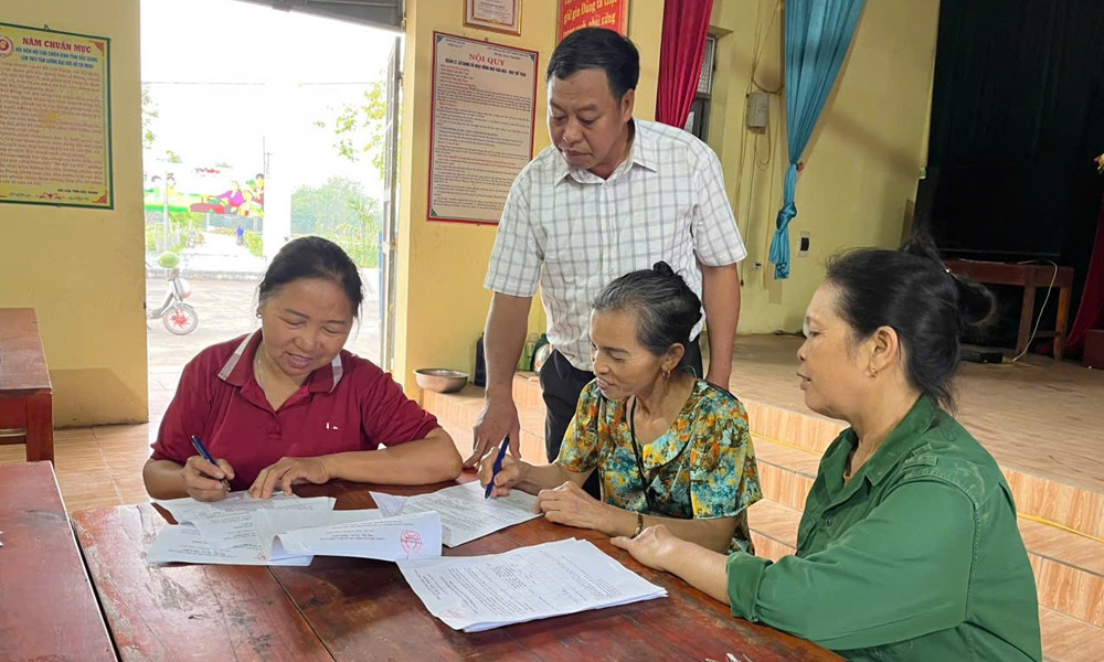 Cán bộ Tổ lấy ý kiến nhân dân thôn Na Gu, xã Cao Xá (Tân Yên) hướng dẫn cử tri viết phiếu lấy ý kiến. Ảnh: ITN bg.jpg