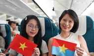 Các hành khách cầm lá cờ đỏ Sao vàng và cờ mặt trận Mặt trận Dân tộc giải phóng Miền Nam Việt Nam - biểu tượng thiêng liêng của hòa bình, độc lập. Ảnh VNA